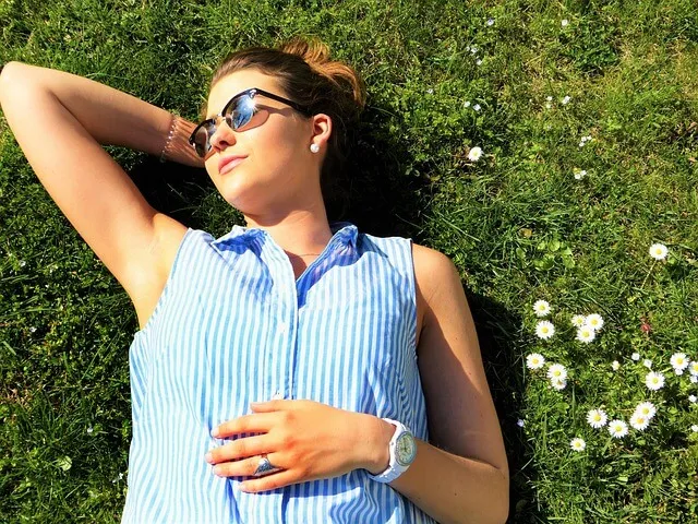 mujer joven descansando cesped sol