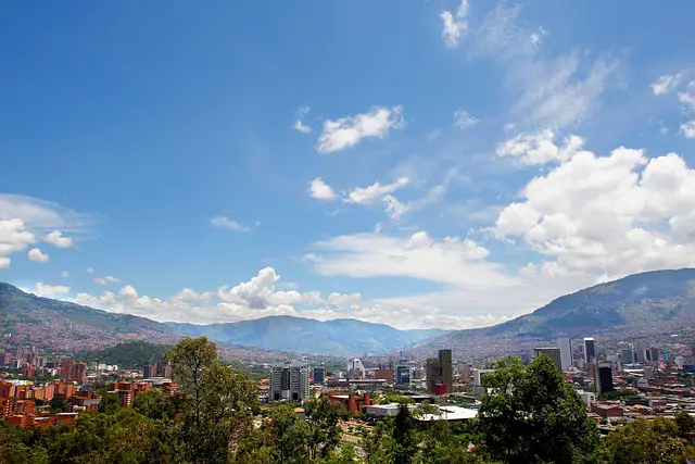 La ciudad de Medellín en Colombia, rodeada de montañas y un cielo azul profundo